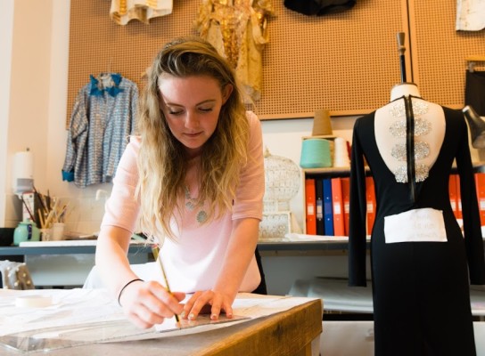 Fashion student measuring fabrics