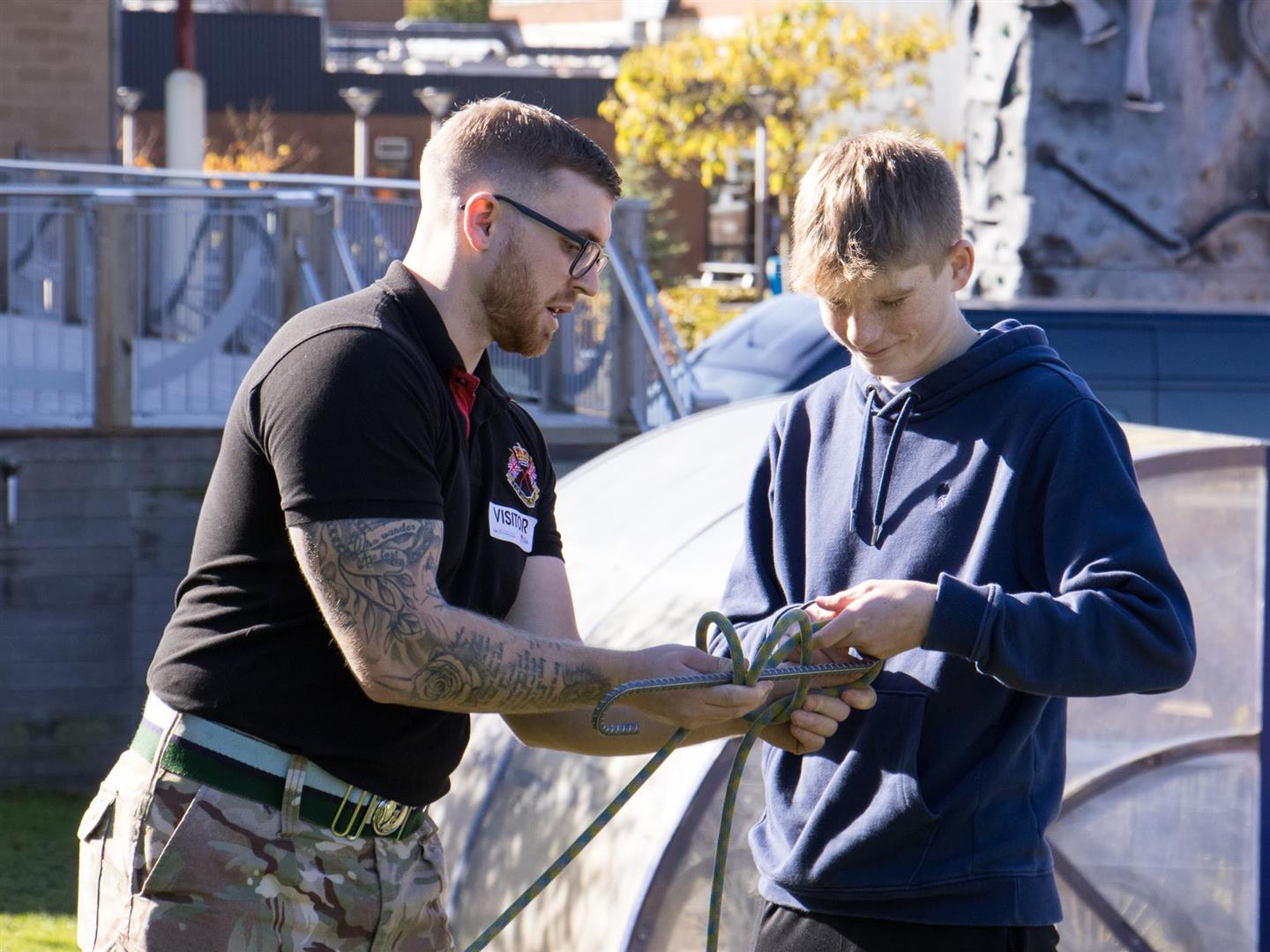 A member of the Army Outreach team demonstrating a rope knot to Uniformed Services student Sam Frost