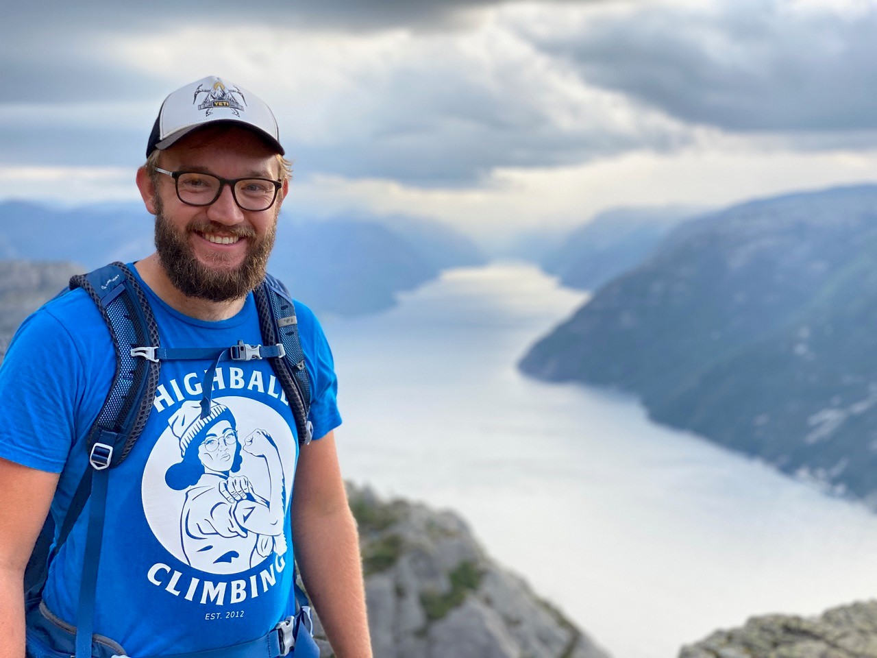 Student Asa Hardy Brownlie stands atop a mountain, overlooking a lake