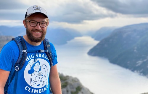 Student Asa Hardy Brownlie stands atop a mountain, overlooking a lake