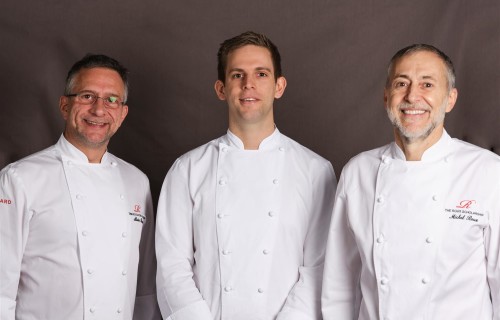 Oli Williamson wearing chef whites and posing with Alain Roux and Michel Roux Jr Large