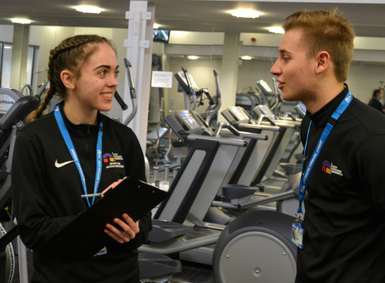 Students Paige Sterry and Ben Brighton surrounded by treadmills