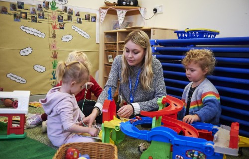 Childcare student with toddlers in nursery